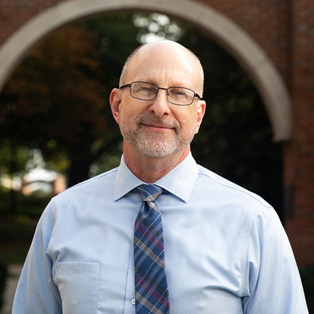 david dewitt - man wearing glasses, blue dress shirt and navy striped tie