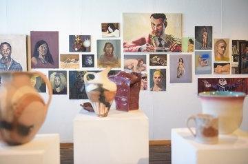 Gallery wall with painting and sculpture on display of students work for RICE Symposium